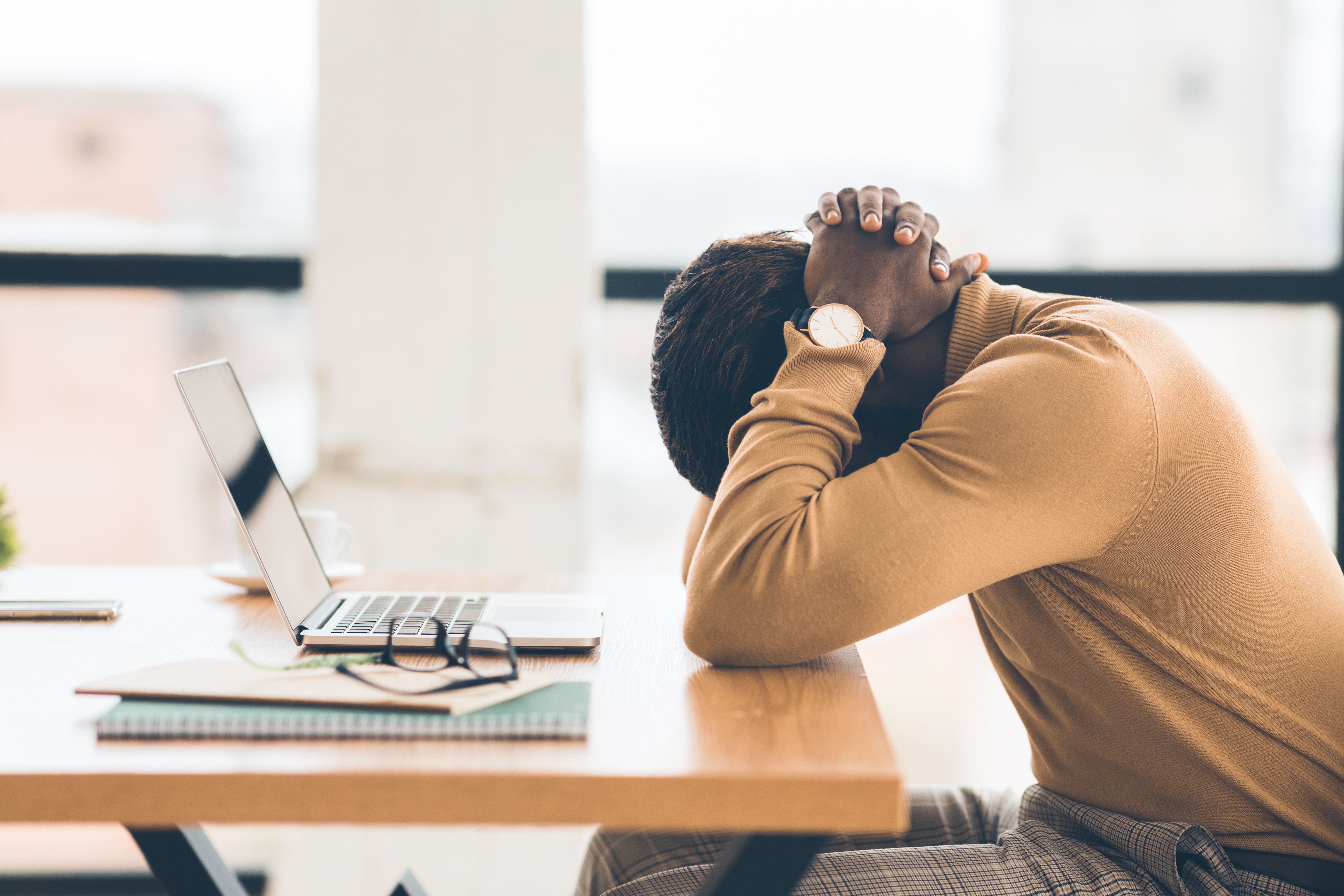 Finance professional facing a demanding workload at a laptop